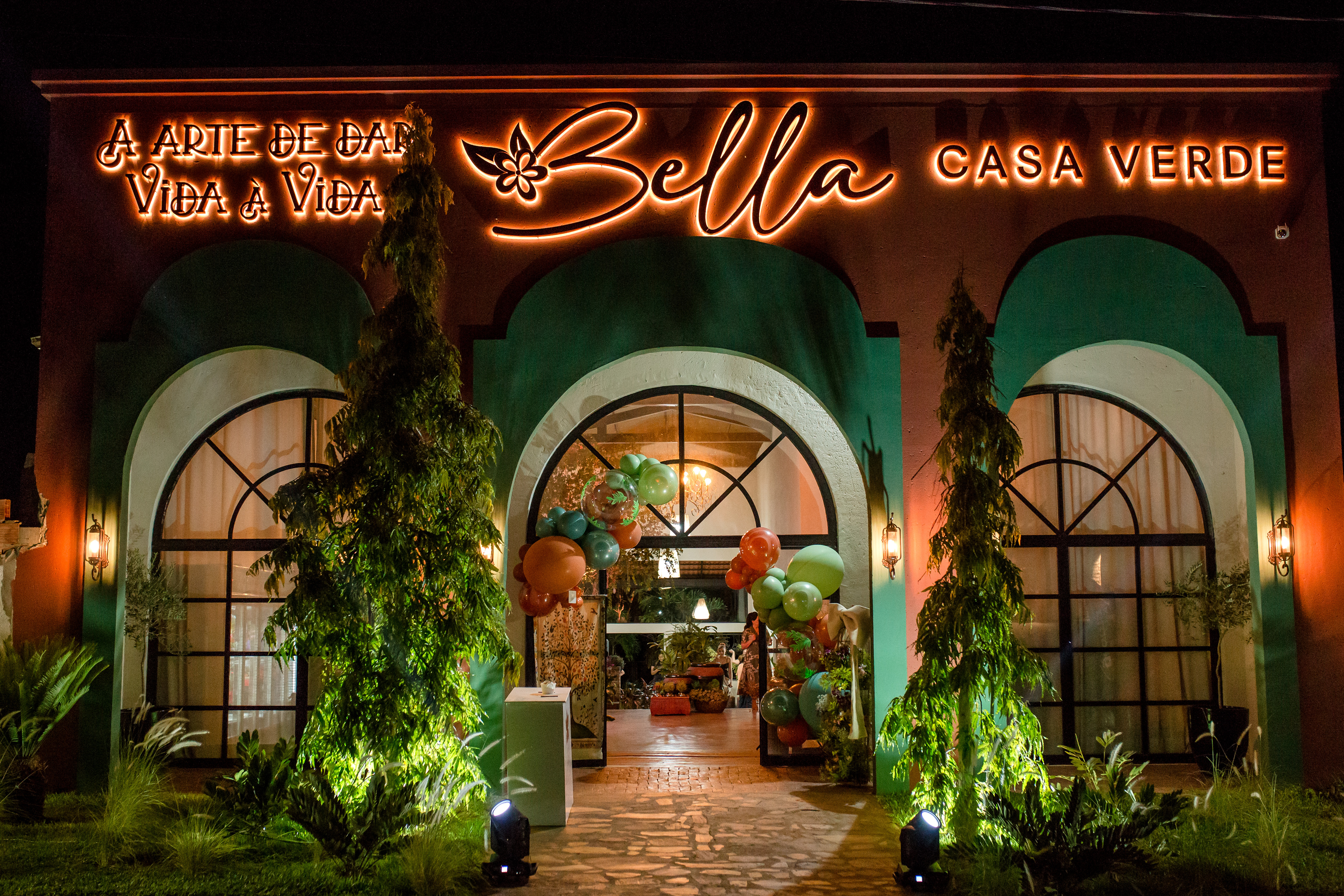 Fachada da loja Bella Casa Verde iluminada à noite
