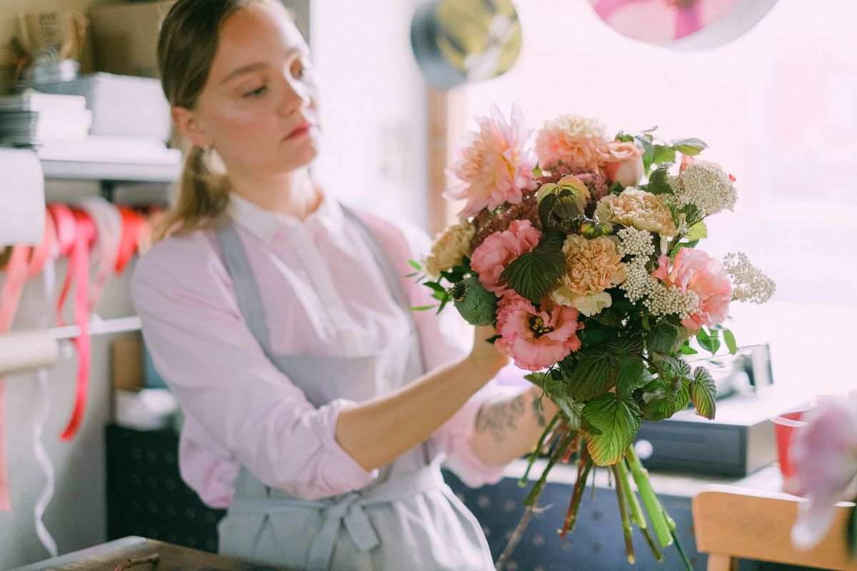 Florista orientando na escolha de flores em ambiente aconchegante