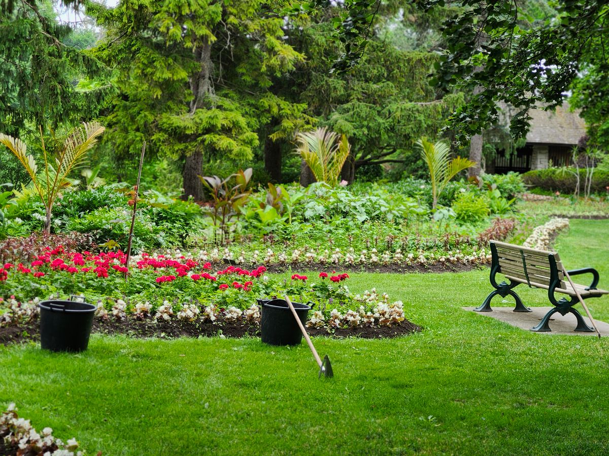 Espaço verde planejado com canteiros e banco